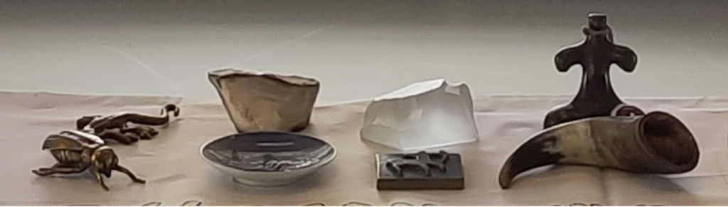 Figure 1. Photo showing totems such as figurines of a fly, a gecko, a petrified stone, a dish with a mermaid, and a tile with a centaur.