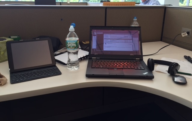 An image from the photo diary of a study participant working at a temporary desk at a client site, with laptop and tablet handy.