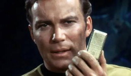 A picture of Star Trek's captain Kirk talking into a mobile phone-like device before mobile phones existed.