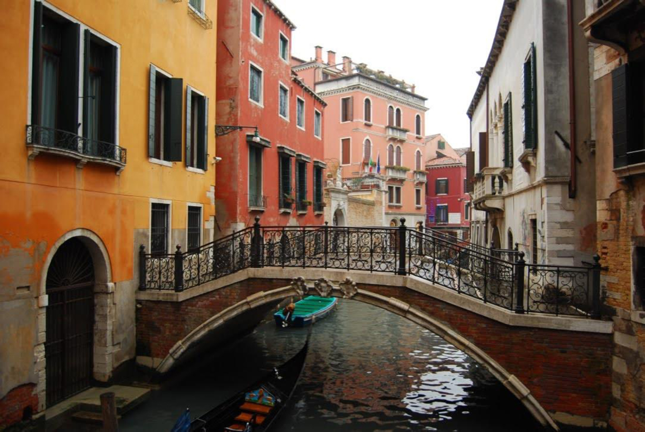 Colourful buildings in the background, with a bridge over a waterway