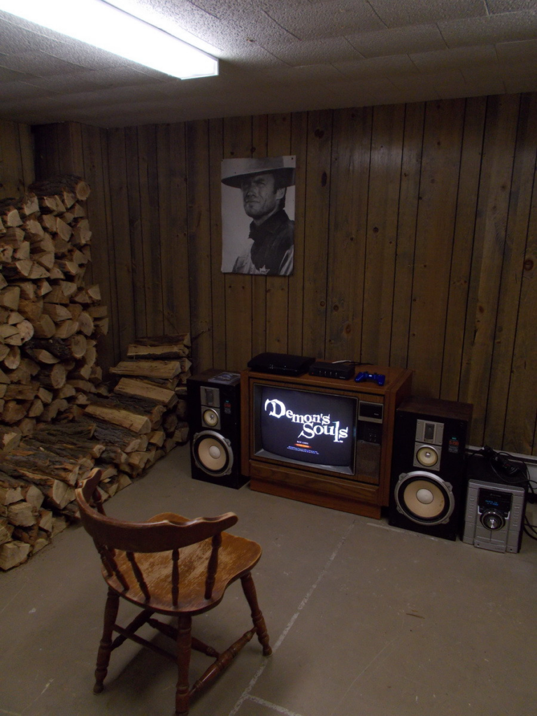 Salsa Shark, 2014 https://www.neogaf.com/threads/show-us-your-gaming-setup-2014-edition.745183/ A universally recognized image in online circles of a wood paneled room containing a pile of firewood, a Clint Eastwood poster, a CRT television sitting on the floor with the opening menu for the game Demons' Souls displayed and an antique wood dining chair sitting about three feet from the television.